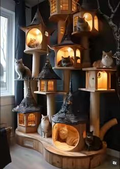 a room filled with lots of different types of cat houses and cats sitting on top of them