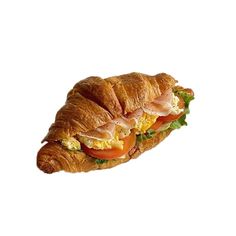 a croissant sandwich with meat, cheese and tomato on it's side