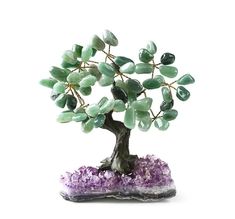 a bonsai tree with green leaves and purple crystals on it's rock base