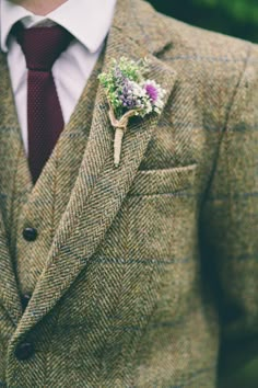 a man wearing a suit and tie with a boutonniere on his lapel