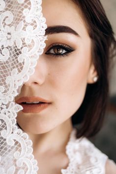 a woman with brown eyes and lace on her face