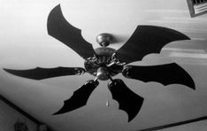 black and white photograph of a ceiling fan with bats on it's blades