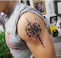 a man with a compass tattoo on his arm