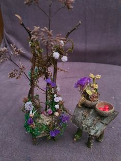 there are two small sculptures made out of wood and flowers on top of each other