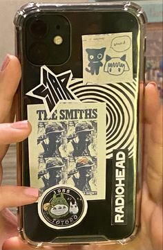 a person holding up a phone case with stickers on it and an ad for tl smith