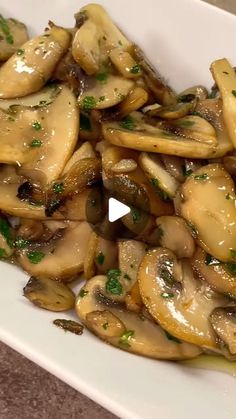 a white plate topped with mushrooms covered in sauce