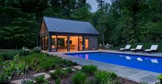 a backyard with a pool and lounge chairs next to it