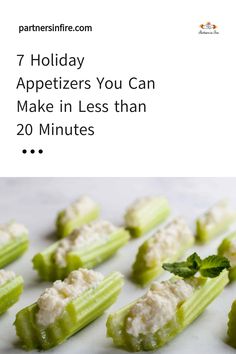 Celery sticks filled with a creamy white spread, garnished with mint leaf.