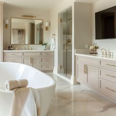 a large white bath tub sitting in a bathroom next to a tv mounted on the wall