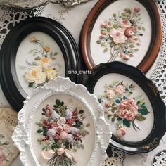 three framed pictures with flowers on them sitting next to lace doily and other decorative items