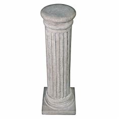 an old white pedestal with columns on it's sides and the base is made out of concrete