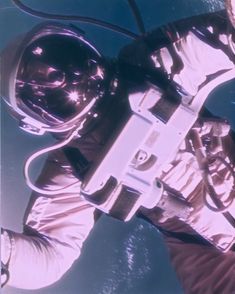 an astronaut floating in the air holding a camera