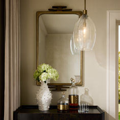 a mirror and vase on a table in a room