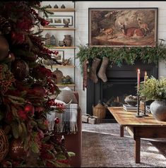 a living room decorated for christmas with stockings on the fireplace mantel and candles lit