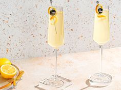 two glasses filled with lemonade sitting on top of a counter