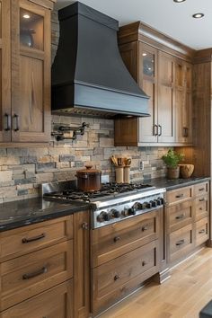 a kitchen with wooden cabinets and black stove top hood over the range in front of an oven