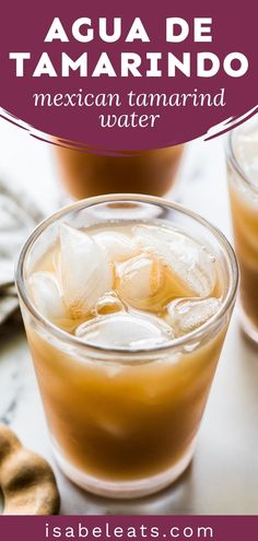 two glasses filled with ice and some type of drink on a table next to cookies