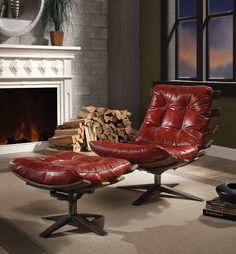 a red leather chair and footstool in front of a fire place with logs