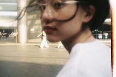 a woman with glasses is walking down the street