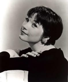 an old black and white photo of a woman with her hand on her chest, looking to the side