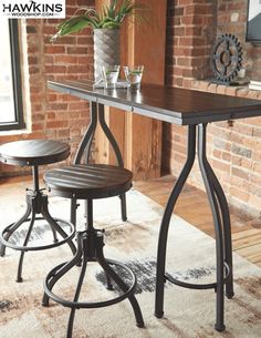 two stools and a table in front of a brick wall with a potted plant on it