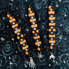 two orange and black beaded necklaces sitting on top of a blue background with stars