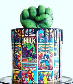 there is a cake decorated with comic books and hulks on the top, as if it were made out of fondant