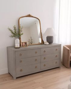 a dresser with a large mirror on top of it