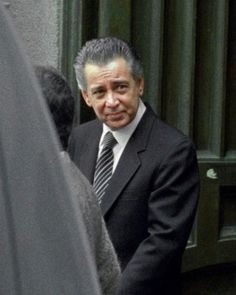 a man in a suit and tie standing outside