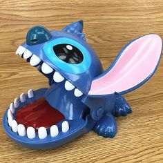 a toy toothbrush holder with teeth and mouth open on a wooden surface, ready to be used as a gadget