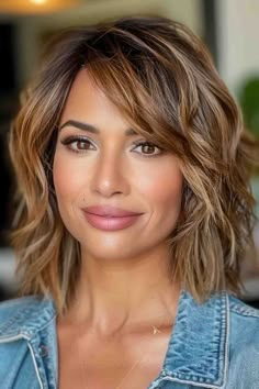 A woman with a tousled bob haircut, side-swept bangs, and caramel highlights Medium Length For Long Face, Bangs On One Side Of Face, Shoulder Length Round Face Haircuts, Long Bob Haircut Thick Hair, Brunette Bob With Side Bangs, Side Swept Medium Hair, Shaggy Bob With Side Swept Bangs, Mid Length Hair 50 Plus, Easy Haircuts For Medium Hair Over 40