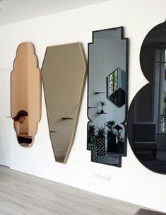 three mirrors mounted to the side of a wall