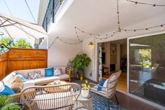 an outdoor living area with patio furniture and string lights