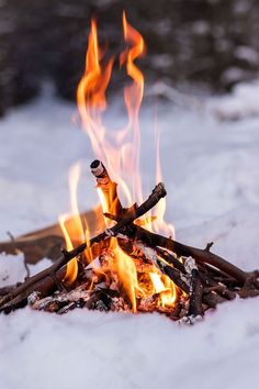 a fire burning in the snow with lots of flames