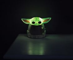 the baby yoda lamp is glowing in the dark