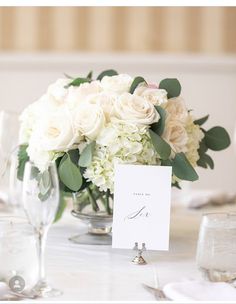 a table set with white flowers and place cards