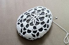 a white crocheted doily with a hook on the end sitting on a table