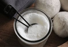 a glass jar filled with white powder next to three round balls