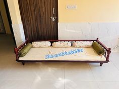 a wooden bed with pillows on it in front of a door that says, shuan bhakt art