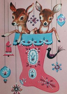 two little deers sitting in a christmas stocking with ornaments hanging from the ceiling