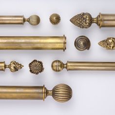 an assortment of brass handles and knobs on a white background, including one with a lion's head