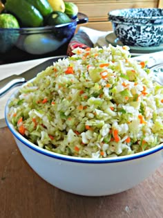 a bowl filled with coleslaw and carrots on top of a wooden table