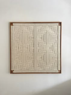 a white wall hanging on the side of a wall next to a wooden framed object