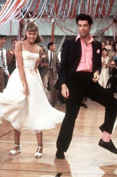 a man and woman dancing on a dance floor in front of a group of people