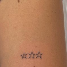 three stars tattoo on the back of a woman's left arm