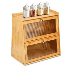 three spice jars sit on top of a wooden cabinet