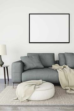 a gray couch sitting on top of a white rug