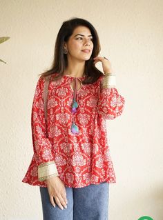 Indian ethnic print handblock print cotton Kurti in this beautiful color combination of red and white pairs beautifully well when worn with solid color pants / denims. Can be styled as it is or worn over a tank top/T-shirt for a stylish layered look.the stylish tie up detail makes for an elegant touch   This cotton kurta is handmade by the artisans of Rajasthan,India in the heart of Pink City Jaipur,known for its block prints and soothing cottons. Model is wearing size M Size chart in pictures. Traditional Ikat Print Tops For Festive Occasions, Festive Ikat Print Top, Red Cotton Kurta With Bandhani Print, Festive Cotton Tops With Printed Motifs, Festive Traditional Tops With Printed Motifs, Festive Red Blouse With Printed Motifs, Red Bohemian Kurta With Printed Motifs, Red Cotton Straight Kurta Tops, Bollywood Style Cotton Blouse With Long Sleeves