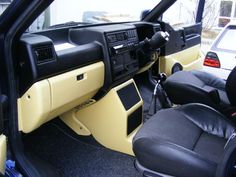 the interior of a car with black leather seats and yellow dash board, including steering wheel