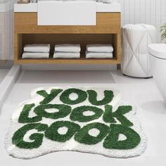 a bathroom rug with the words you look good written on it in green and white